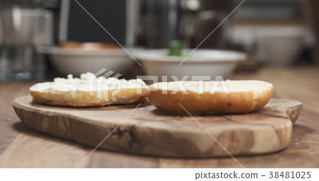 cream cheese on bagel on wood board 38481025