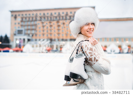 Young woman with skates in hands on skating rink 38482711