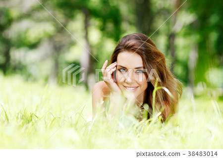 young woman in blue dress lying on grass young woman in blue dress lying on grass 38483014