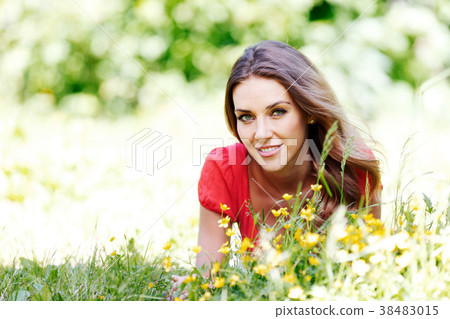 young woman in red dress lying on grass young woman in red dress lying on grass 38483015