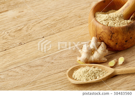 Wooden mortar and pestle with ginger and grind 38483560