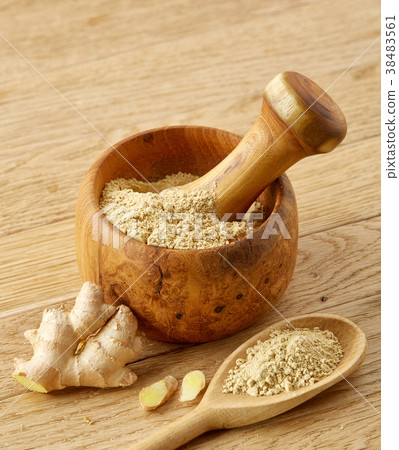 Wooden mortar and pestle with ginger and grind 38483561