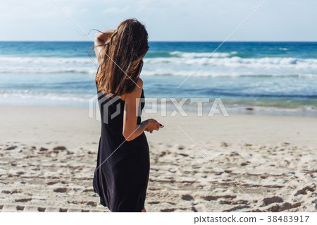 Young beautiful girl looks afar at sea Young beautiful girl looks afar at sea 38483917