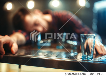 Drunk man sleeps at bar counter, alcohol addiction Drunk man sleeps at bar counter, alcohol addiction 38483933