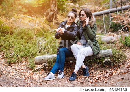 two beautiful girls sat down in the forest two beautiful girls sat down in the forest 38484186