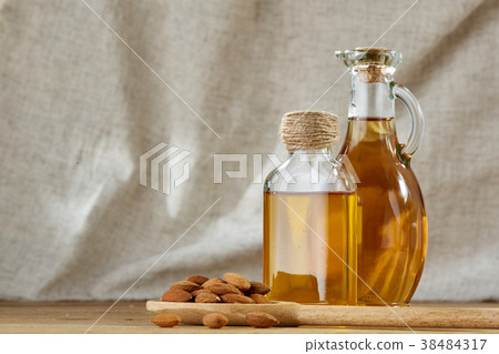Aromatic oil in a glass jar and bottle with almond Aromatic oil in a glass jar and bottle with almond 38484317