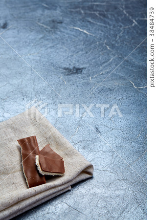 glass cup of black tea with chocolate pieces on a 38484739