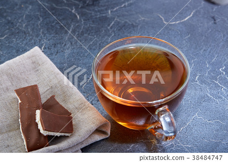 glass cup of black tea with chocolate pieces on a glass cup of black tea with chocolate pieces on a 38484747