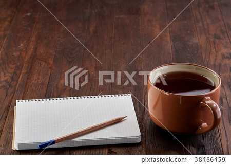 Cup of tea with cookies, workbook and a pencil on 38486459