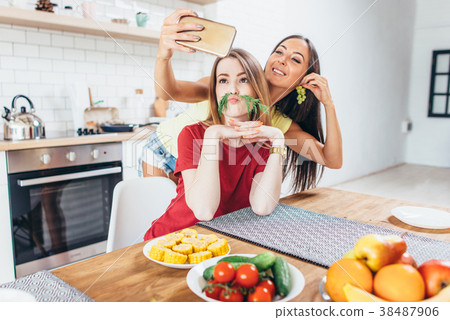 Women preparing food playing with vegetables in 38487906