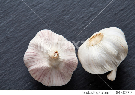 Close up view of two garlic bulbs arranged on a Close up view of two garlic bulbs arranged on a 38488779