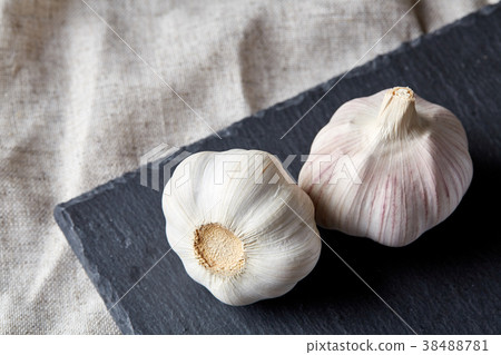 Close up view of two garlic bulbs arranged on a Close up view of two garlic bulbs arranged on a 38488781
