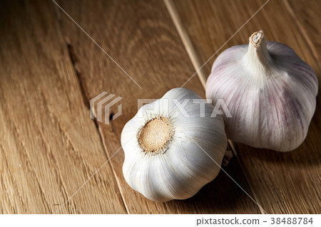 Close up view of two garlic bulbs arranged on a Close up view of two garlic bulbs arranged on a 38488784