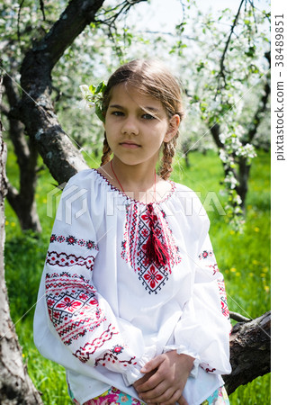 Cute girl dressed in embroidery in the garden Cute girl dressed in embroidery in the garden 38489851