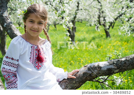 Cute girl dressed in embroidery in the garden Cute girl dressed in embroidery in the garden 38489852