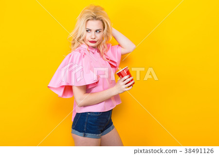 Blonde woman in pink blouse with red cup Blonde woman in pink blouse with red cup 38491126
