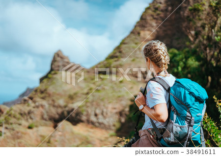 Woman with camera and backpack in front of the 38491611