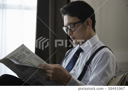 Stylish businessman reading English newspaper 38491967