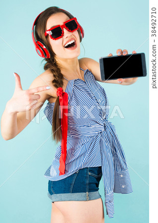 Young sexy woman with headphones and cellphone Young sexy woman with headphones and cellphone 38492710