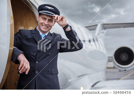 Cheerful pilot near airplane outdoor Cheerful pilot near airplane outdoor 38498459