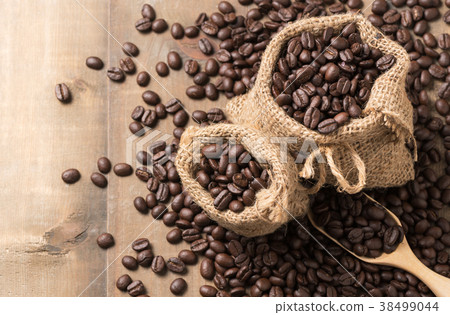 roasted coffee beans in sack with wood scoop 38499044
