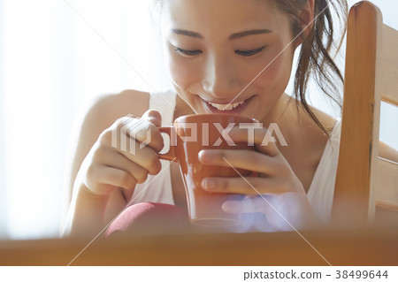 A woman drinking a drink 38499644