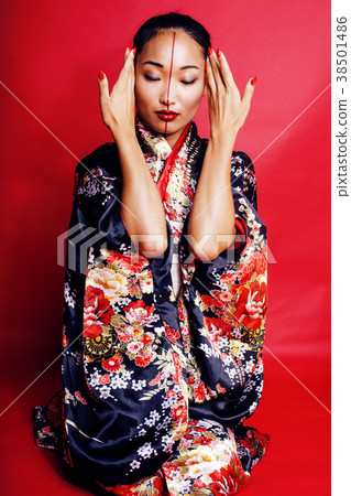 young pretty geisha on red background posing in 38501486