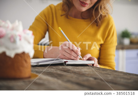 Smiling lady writing down her best recipes 38501518