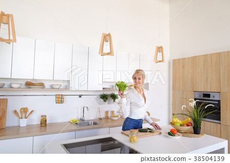 Beautiful housewife woman holding green lettuce 38504139