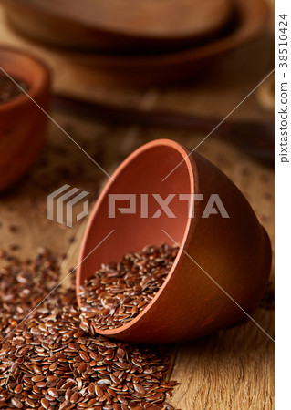 An overturned ceramic bowl with linseeds on a An overturned ceramic bowl with linseeds on a 38510424