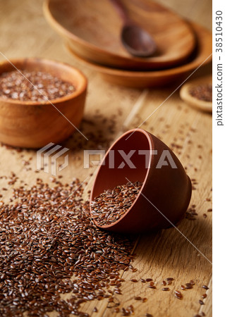 An overturned ceramic bowl with linseeds on a An overturned ceramic bowl with linseeds on a 38510430