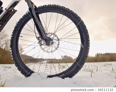 Front wheel of mountain bike while snow riding. 38511110