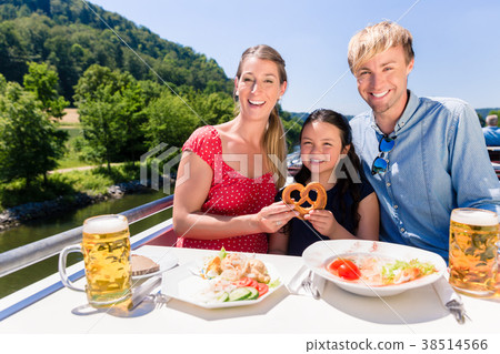 Family at lunch on river cruise with beer glasses 38514566