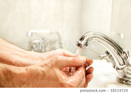 Washing hands in washbasin. Focus on faucet 38514720