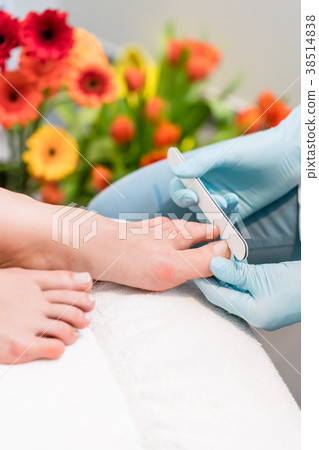 Close-up of the hands of a nail technician wearing 38514838