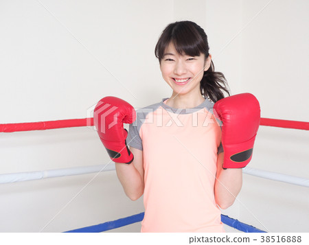 A woman who puts on a boxing glove and laughs A woman who puts on a boxing glove and laughs 38516888