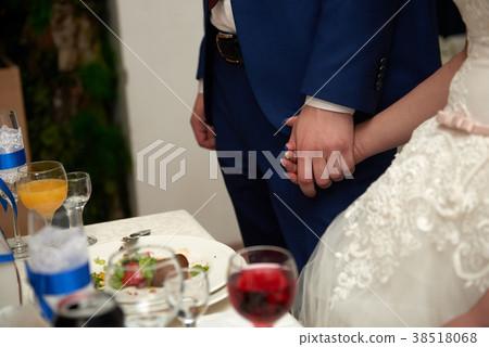 Bride and groom holding hands close up Bride and groom holding hands close up 38518068