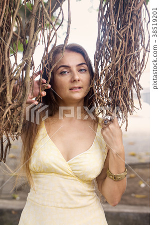 portrait of a woman near a banyan tree 38519201
