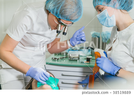 Woman at dentist clinic gets dental treatment to 38519889