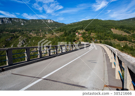 long road on the bridge in the mountains 38521666