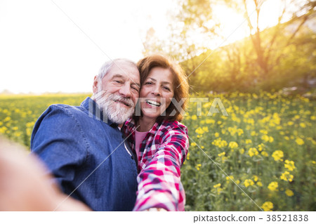 Senior couple with smartphone outside in spring 38521838