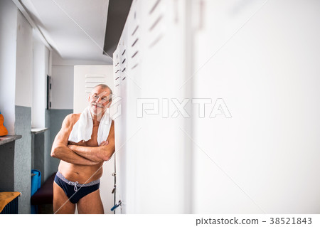Senior man standing by the lockers in an indoor 38521843