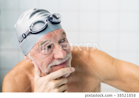 Portrait of a senior man in an indoor swimming Portrait of a senior man in an indoor swimming 38521858