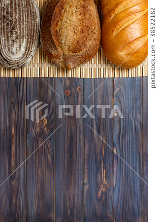 Assortment of baked bread on wooden table  38522182