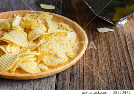 Snacks in a wooden dish on a table Snacks in a wooden dish on a table 38523472