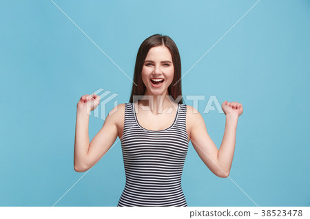 The happy woman standing and smiling against blue The happy woman standing and smiling against blue 38523478