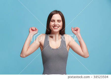 The happy woman standing and smiling against blue 38523504