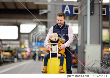 Cute little boy and his father waiting express train on railway station platform 38524511