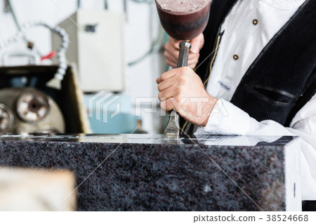 Stone mason working on tombstone in workshop 38524668