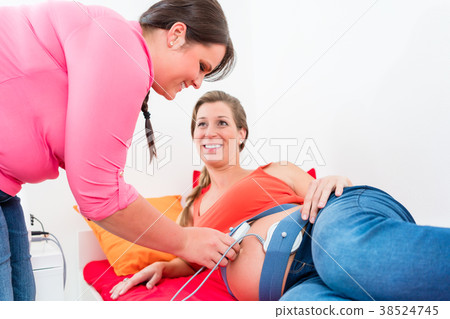 Smiling expectant mother and midwife adjusting 38524745